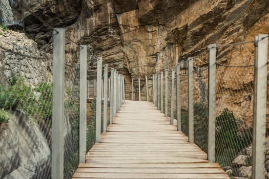 Empty wooden walkway next to the cliffs of the Caminito Del Rey in El Chorro, Spain.