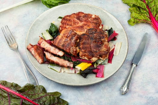Delicious grilled meat steak and fresh herb salad. Top view.