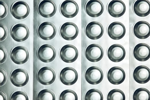 Tablets and capsules pill in blister packaging arranged in row. Medicines - tablets, pills in blister pack, medications drugs. Pharmaceutical industry concept. Pharmacy drugstore. Background with copy space