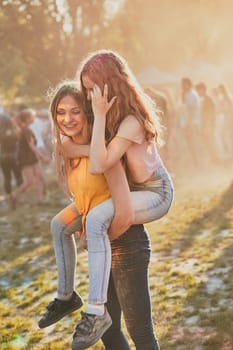 Portrait of happy smiling young girls with colorful paints on faces and clothes. Two friends spending time on holi color festival