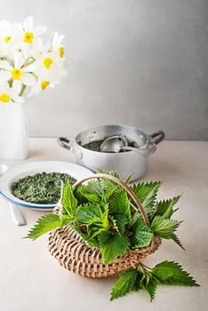 Young shoot Nettle leaves for healthy dish on bright table background. Spring healthy detox food