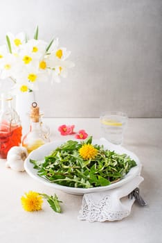 Fresh dandelion salad with dressing. Healthy spring food concept