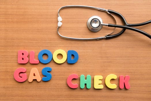 Blood gas check colorful word with stethoscope on the wooden background