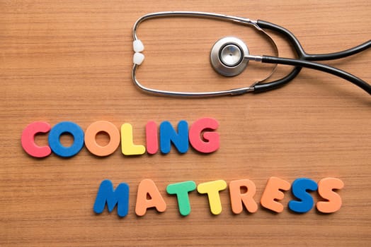 Cooling mattress colorful word with stethoscope on the wooden background