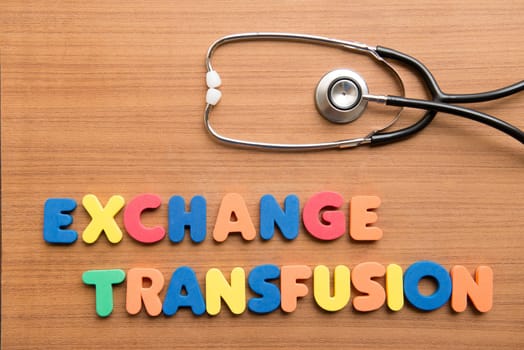 Exchange transfusion colorful word with stethoscope on the wooden background