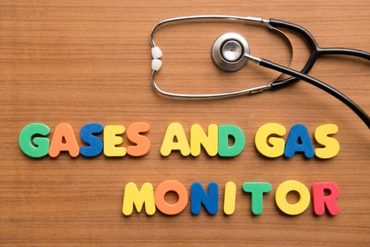 Gases and Gas monitor colorful word with stethoscope on the wooden background