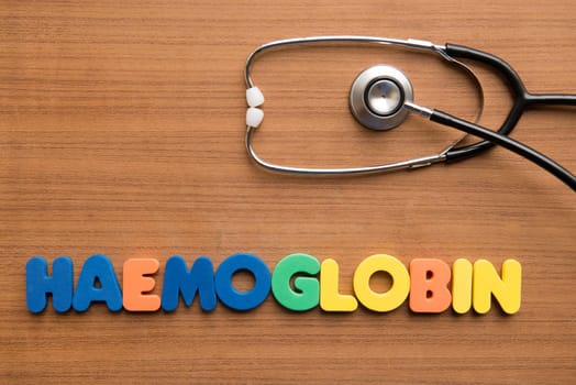 Haemoglobin colorful word with stethoscope on the wooden background