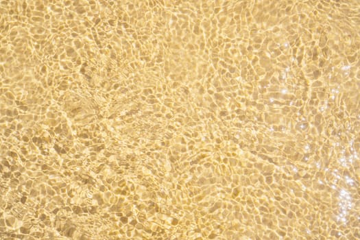 Texture of wet yellow sea sand. Sea coast. Tourism and travel. Calm and serenity. Natural background. Natural texture. Dunes. Abstract drawing. Close-up. Ecology.