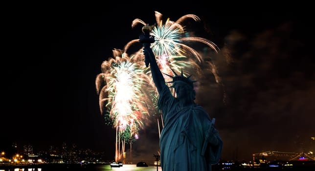 The silhouette of Statue of Liberty Statue of Liberty and July 4th fireworks over Hudson River