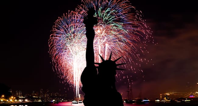 The silhouette of Statue of Liberty Statue of Liberty and July 4th fireworks over Hudson River
