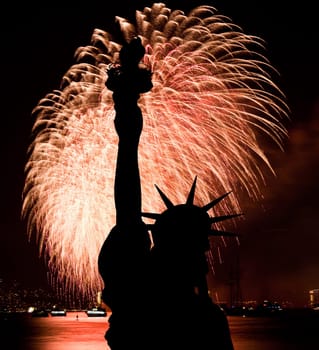 The silhouette of Statue of Liberty Statue of Liberty and July 4th fireworks over Hudson River