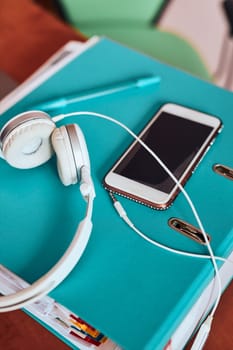 Binder mobile phone headphones on a desk in home office