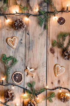 Christmas decoration with lights and pine twigs on wooden table