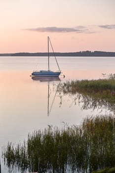 Yacht moored near a harbour in coast at sunrise. Candid people, real moments, authentic situations