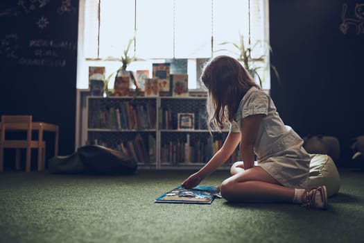 Child solving riddle in book in school library. Primary school pupil is involved in book with riddles. Smart girl learning to solve problems. Benefits of everyday practice. Child curiosity