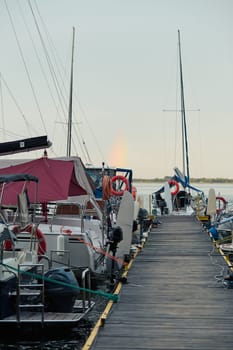 Yachts and boats moored in a harbour at sunrise. Candid people, real moments, authentic situations