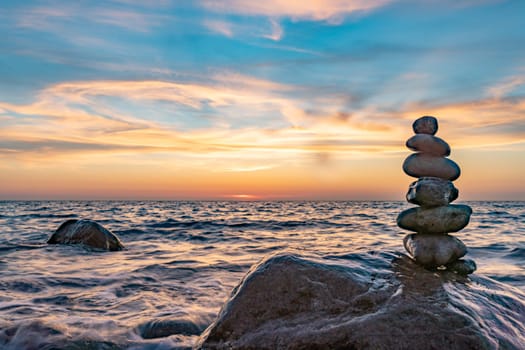 Stone pyramids and glass sphere on the dreamy Baltic Sea sand beach on Rügen for the spectacular sunset