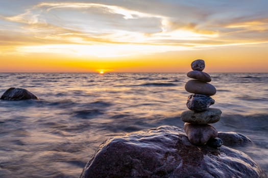 Stone pyramids and glass sphere on the dreamy Baltic Sea sand beach on Rügen for the spectacular sunset