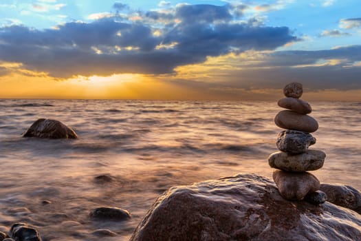 Stone pyramids and glass sphere on the dreamy Baltic Sea sand beach on Rügen for the spectacular sunset