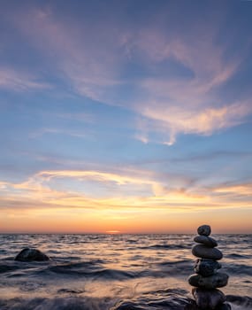 Stone pyramids and glass sphere on the dreamy Baltic Sea sand beach on Rügen for the spectacular sunset