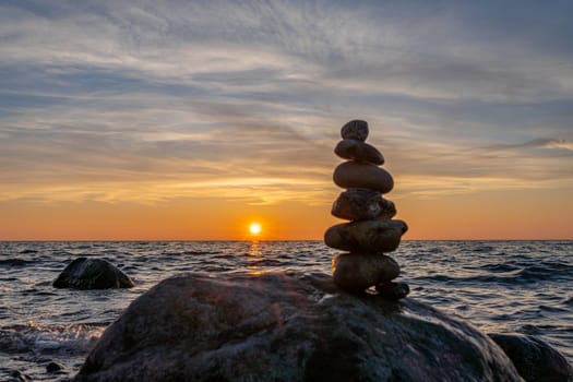 Stone pyramids and glass sphere on the dreamy Baltic Sea sand beach on Rügen for the spectacular sunset