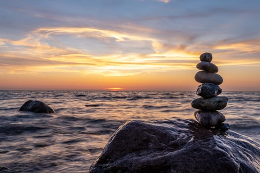 Stone pyramids and glass sphere on the dreamy Baltic Sea sand beach on Rügen for the spectacular sunset