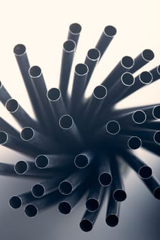 Bunch of black plastic straws scattered in container over plain grey background. Copy space for text