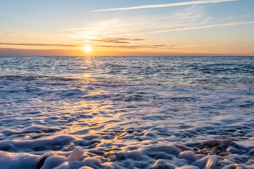 orange, sunset between rocks in the sea of the Baltic Sea near Dranske on the island of Rügen-	Beautiful sunset over the sea with waves and rocks in the foreground