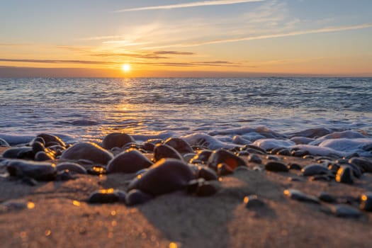 orange, sunset between rocks in the sea of the Baltic Sea near Dranske on the island of Rügen-	Beautiful sunset over the sea with waves and rocks in the foreground