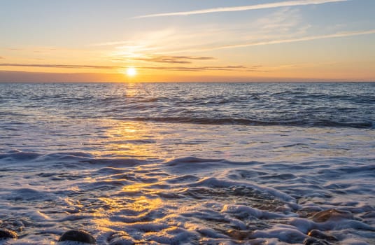 orange, sunset between rocks in the sea of the Baltic Sea near Dranske on the island of Rügen-	Beautiful sunset over the sea with waves and rocks in the foreground