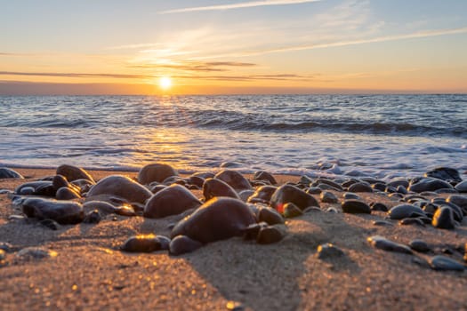 orange, sunset between rocks in the sea of the Baltic Sea near Dranske on the island of Rügen-	Beautiful sunset over the sea with waves and rocks in the foreground