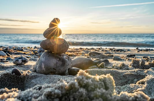 Stone pyramids and glass sphere on the dreamy Baltic Sea sand beach on Rügen for the spectacular sunset