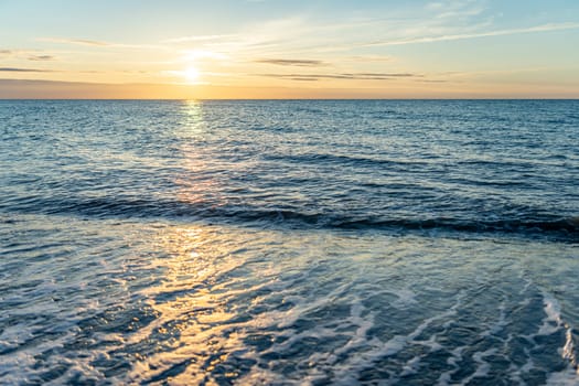 orange, sunset between rocks in the sea of the Baltic Sea near Dranske on the island of Rügen-	Beautiful sunset over the sea with waves and rocks in the foreground