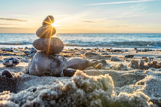 Stone pyramids and glass sphere on the dreamy Baltic Sea sand beach on Rügen for the spectacular sunset