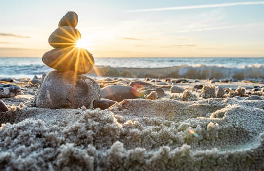 Stone pyramids and glass sphere on the dreamy Baltic Sea sand beach on Rügen for the spectacular sunset
