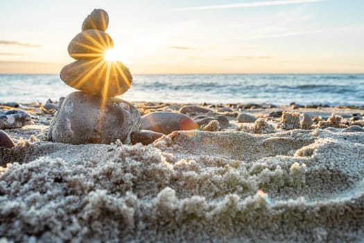 Stone pyramids and glass sphere on the dreamy Baltic Sea sand beach on Rügen for the spectacular sunset