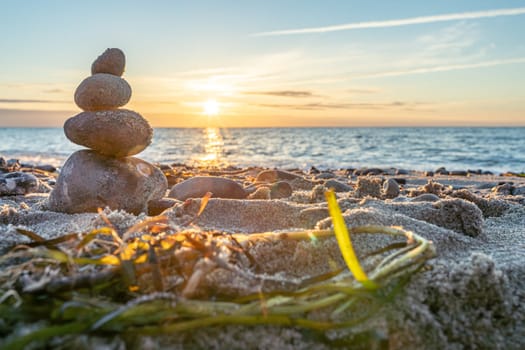 Stone pyramids and glass sphere on the dreamy Baltic Sea sand beach on Rügen for the spectacular sunset