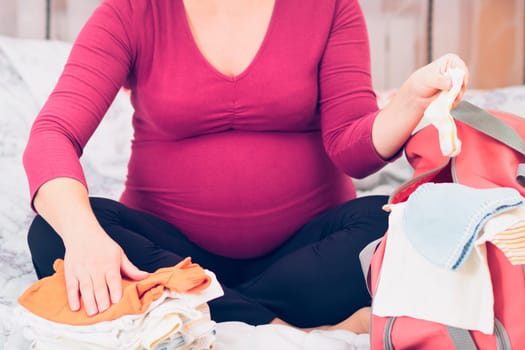 Pregnant woman packing hospital bag preparing for labor
