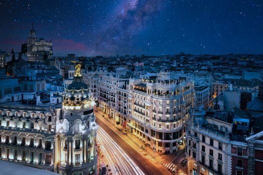 Rays of traffic lights on Gran via street, main shopping street in Madrid at night. Spain, Europe.