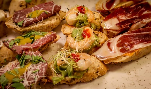 Lots of bites with cheese and ham in a tapas bar.