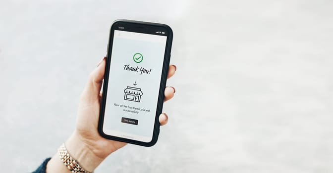Shopping online. Ordering product online using smartphone. Female hands using smartphone for online shopping. Order confirmation - thank you. Your order has been placed successfully - displayed in store app on smartphone screen