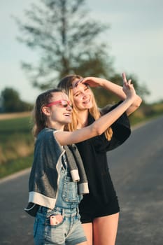 Teenage smiling happy girls having fun walking outdoors, hanging, spending time together on summer day