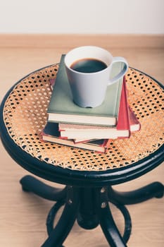 A few books with cup of coffee on chair