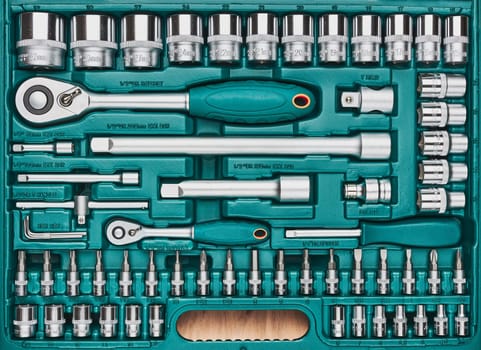 Ratchet with many attachments in plastic case. Work tools. Universal tool set. Background