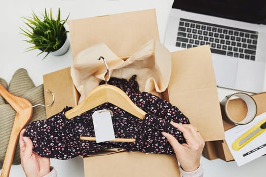 Business owner packing online order to delivery to customer. Preparing parcel box with clothes product from online shop