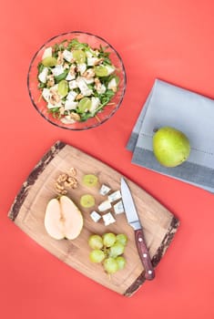 Making salad with grapes, pear, walnut and blue cheese