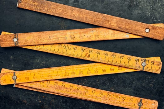 Wooden measure. Old ruler on metal surface. Measuring tool. Technical background with copy space