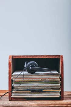 Stack of many black vinyl records and headphones put on the top of stack. Candid people, real moments, authentic situations
