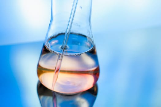 Flask with colorful fluid, sample in chemical laboratory ready to analyse