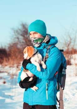 Boy holding the dog during  the winter trip